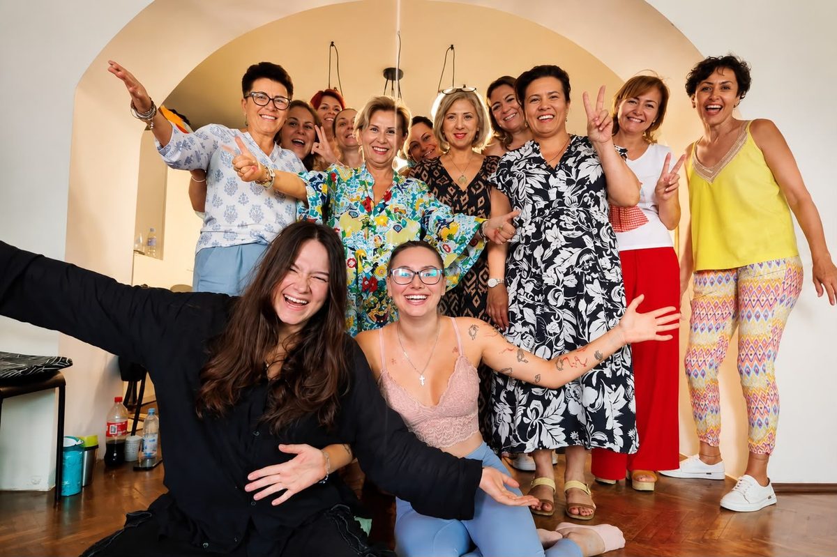 Grup de participante la o sesiune de constelații familiale, râzând și pozând împreună la finalul întâlnirii